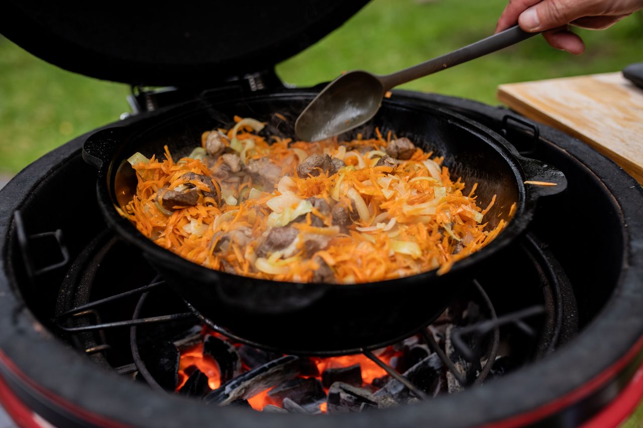 Meilleur kamado français : cuisson en cocotte en fonte sur la grille d'un kamado en céramique au charbon de bois